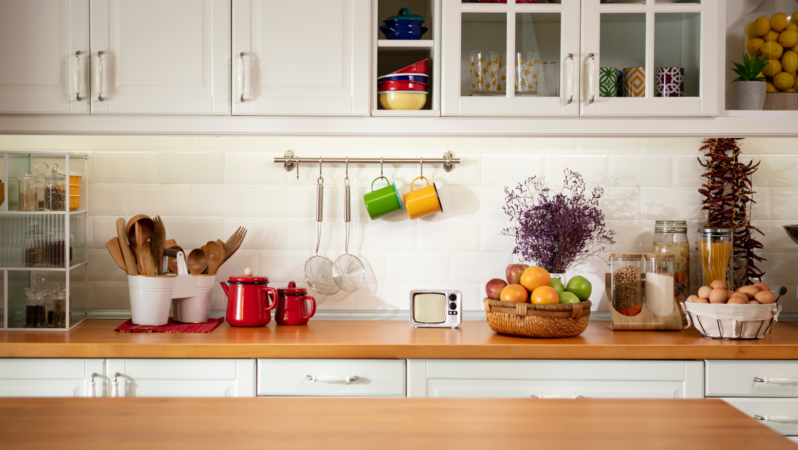 Kitchen countertop with plants and utensils.