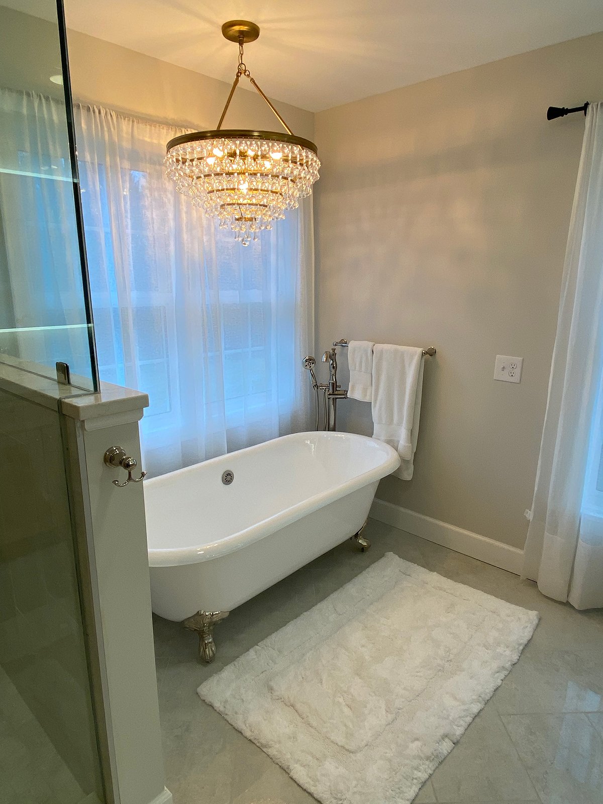 Bathroom interior with a freestanding tub, chandelier and towel