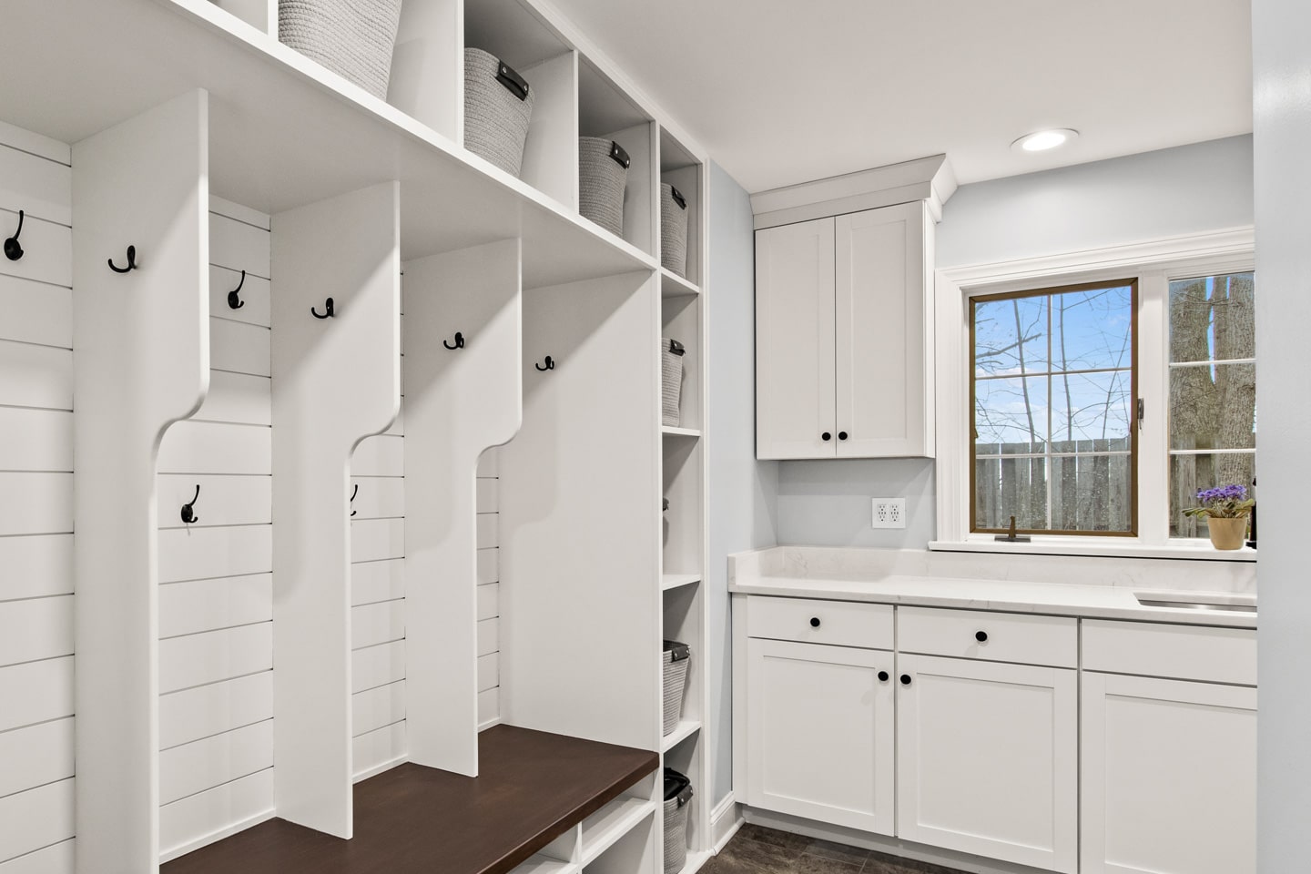A modern mudroom with built-in storage and cabinets. The room features a window with a view.