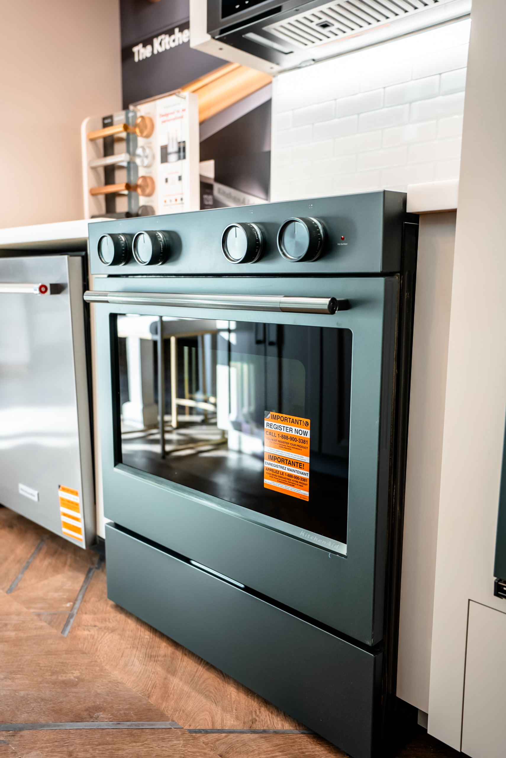 Green oven with a large window. The oven has three knobs on top.